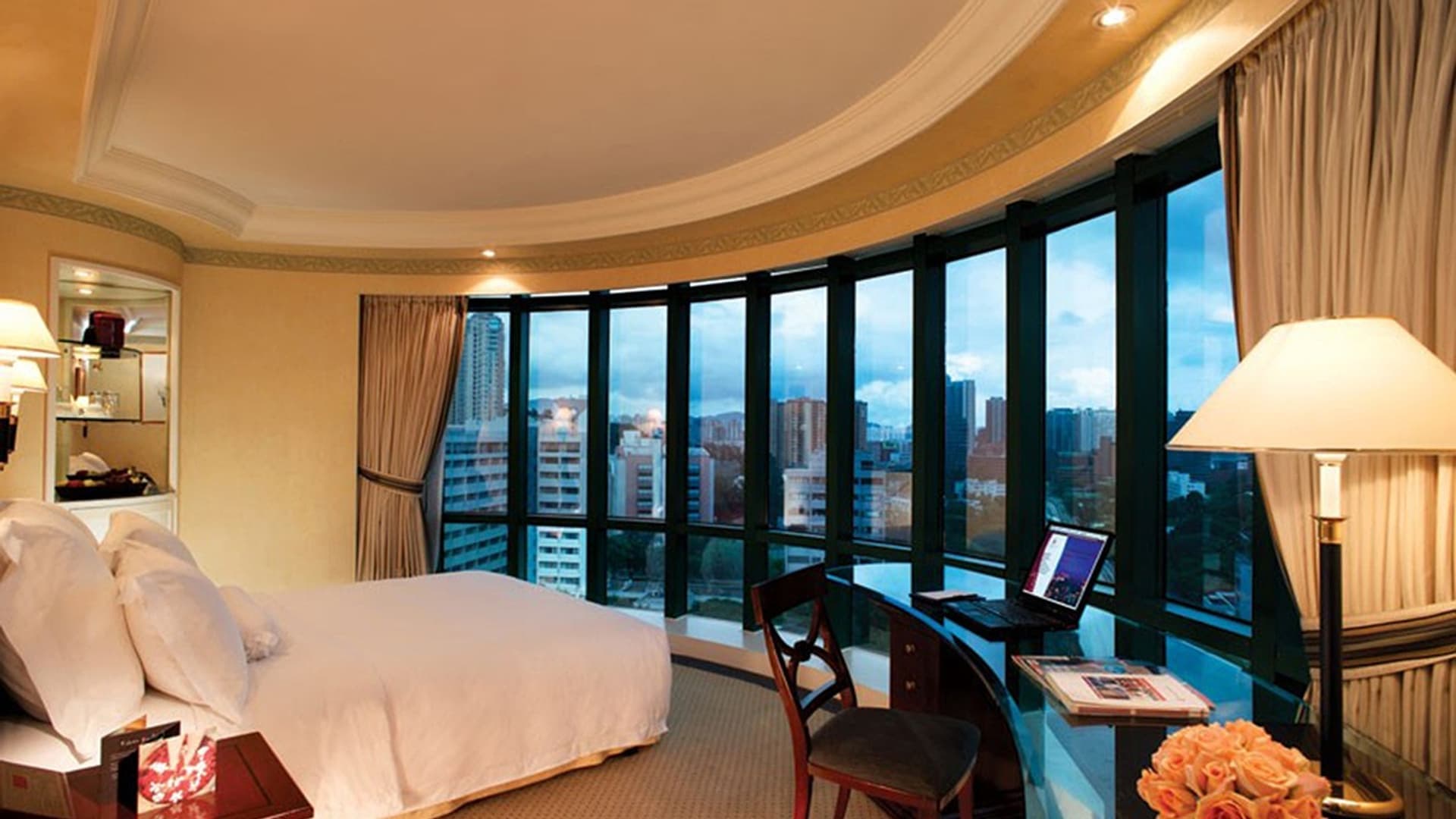 Hotel room with a desk and a city view